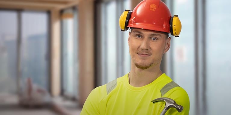 En man iklädd varselkläder och röd bygghjälm